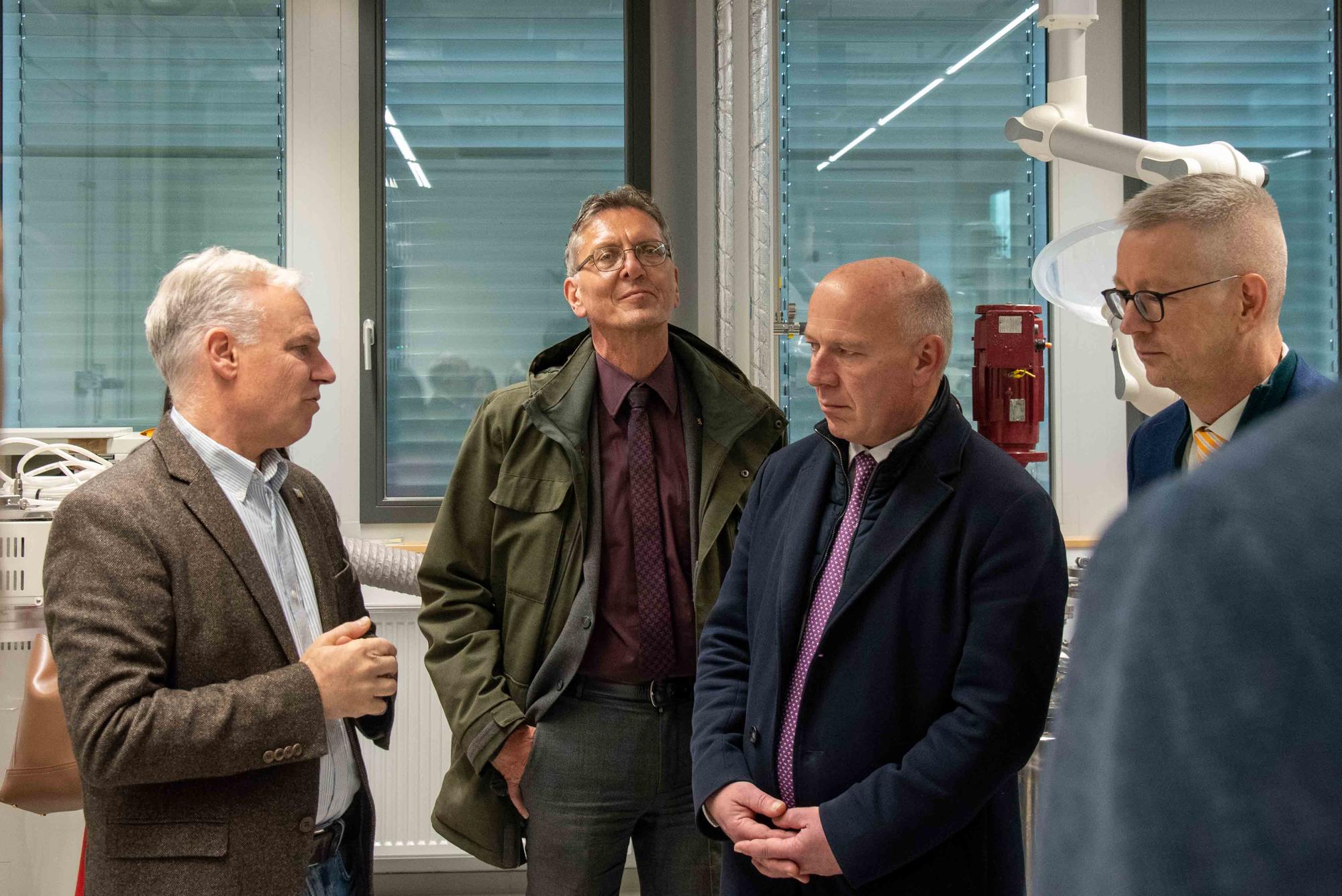Chemie-Professor Rainer Haag (l.) erklärt, wie im Scale-up-Lab Entwicklungen aus der Forschung in größeren Mengen produziert werden können. v.r.n.l.: Günter M. Ziegler, Kai Wegner, Christian Gaebler