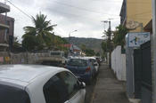 Cars, palm trees, and green mountains in the background dominate the cityscape of Saint-Denis.