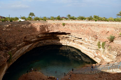 Guests relax and dangle their feet at the Bimah Sinkhole.