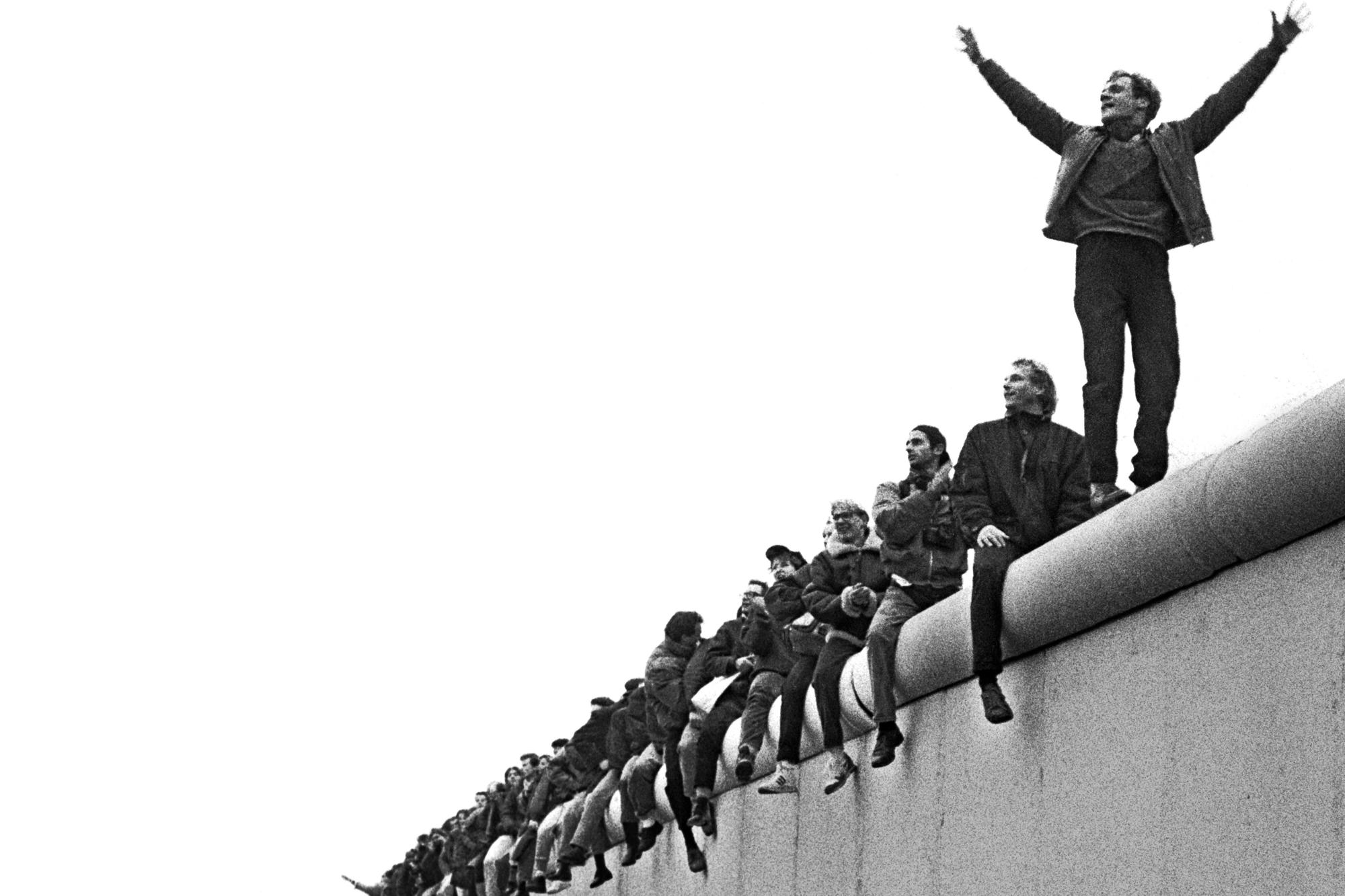 Kollektive Euphorie. Menschen sitzen und tanzen am 12. November 1989 am Potsdamer Platz auf der Berliner Mauer.