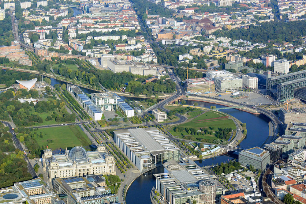 Der Ost-West-Riegel aus Kanzleramt, Paul-Löbe-Haus und Marie-Elisabeth-Lüders-Haus verbindet die ehemals getrennten Teile Berlins und Deutschlands. Ein Erweiterungsbau des Kanzleramts über die Spree ist geplant, wegen der Kosten aber umstritten.