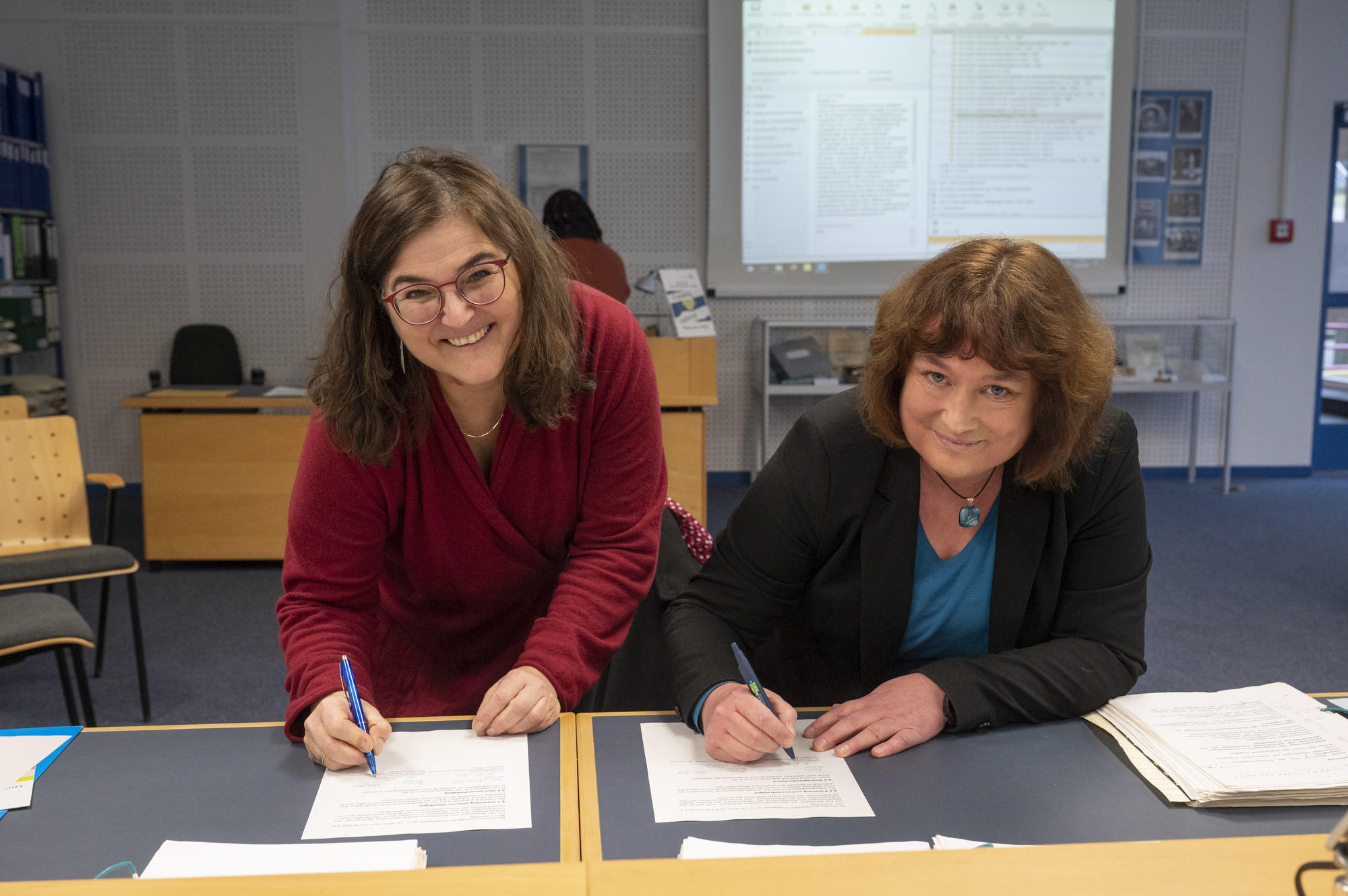 Unterzeichnung der Schenkung durch Matthia Rischke von der Schule für Logopädie am Berliner Bildungscampus für Gesundheitsberufe und Birgit Rehse vom Universiätsarchiv der FU Berlin (v. r. n. l.)